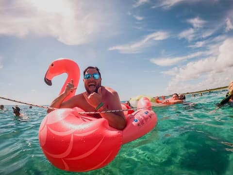 Guest floating in turquoise water on a pool float